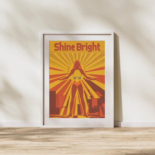 A vibrant poster featuring a powerful female figure standing in a confident stance, surrounded by rays of light in bold red, yellow, and orange colors. The words &quot;Shine Bright&quot; are displayed at the top in a strong, modern font.